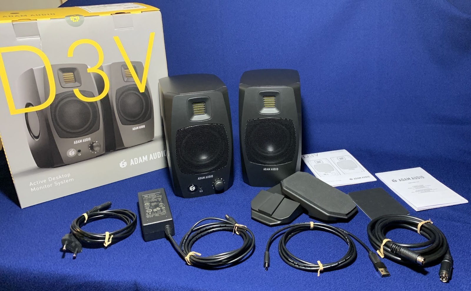 Adam Audio D3V Review: Compact Studio Monitors with Serious Low-End Authority 9 When you open the box, on top are cables neatly secured with double ties, an external power supply and documentation.